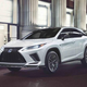a white 2021 lexus rx 450 h parked on a city street at night, viewed from the front left corner of the car